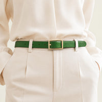 Ceinture fine en cuir vert La Ceinture Pour Femme avec boucle dorée portée sur un pantalon beige élégant