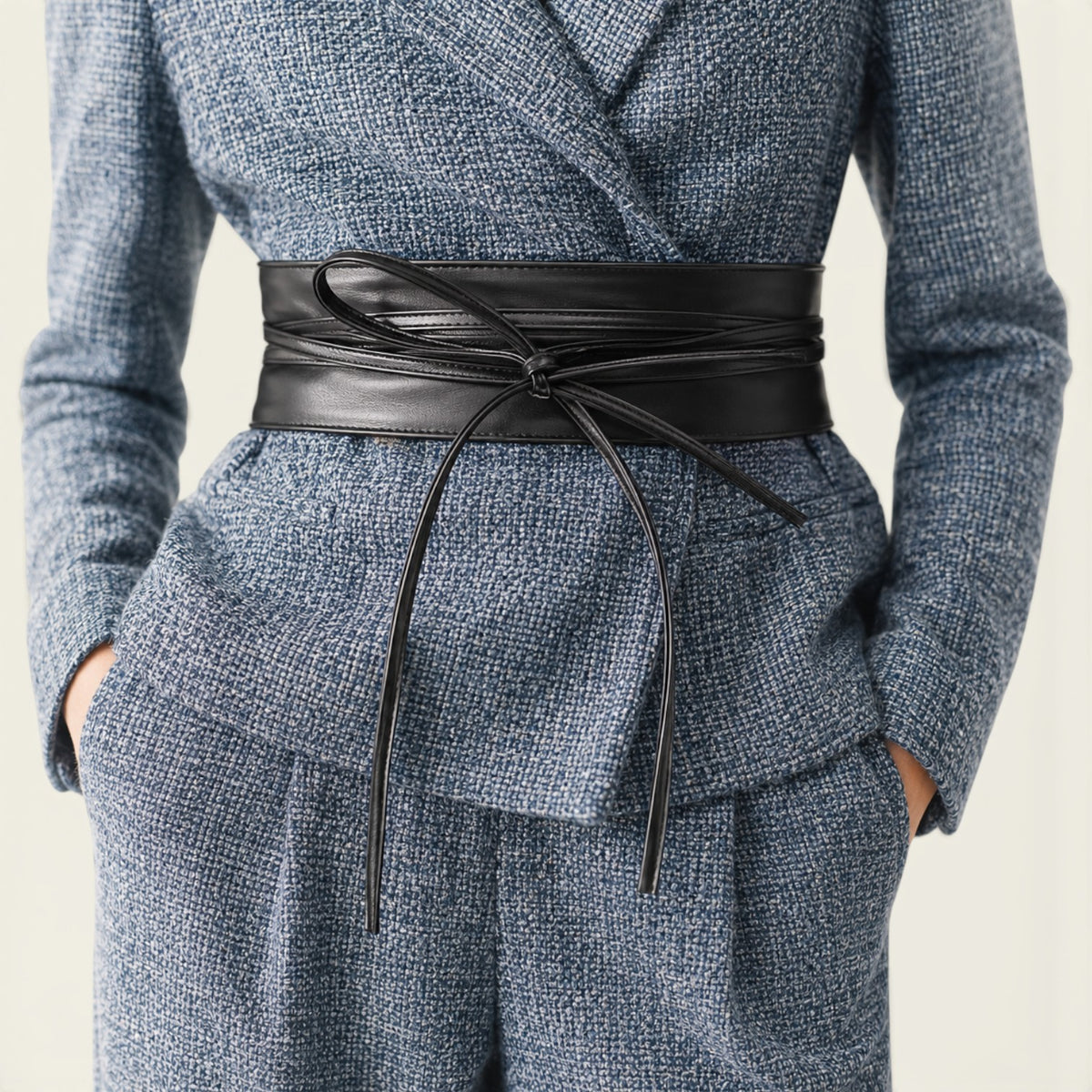 Ceinture à nouer noire La Ceinture Pour Femme Célestine en similicuir avec longs pans sur un tailleur bleu chiné